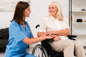 A doctor talks with an elderly patient, both smiling in a well-lit room.